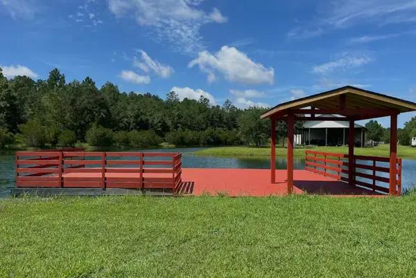 The red covered dock reaching out over the pond