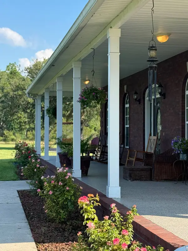 The front porch, with rocking chairs and roses along the path
